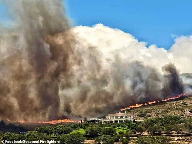 Clouds of smoke rise above a forest fire near a villa on the island of Andros in a photo taken last week