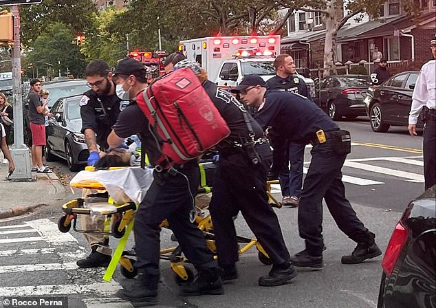 After firing her gun, Wu waited in the house for police to arrive and calmly confessed to the crimes.  (photo: one of the victims is wheeled from the scene on a stretcher)