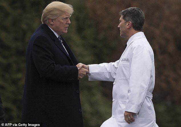 US President Donald Trump shakes hands with White House physician Admiral Dr.  Ronny Jackson, after his annual physical at Walter Reed National Military Medical Center in Bethesda, Maryland, January 12, 2018