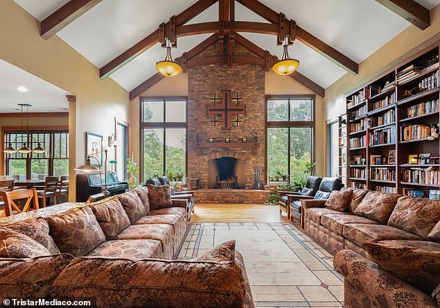 The cavernous living room, affectionately called the Great Room by the owners, features dramatic cathedral ceilings with wood vaults and a brick fireplace