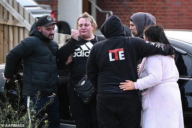 Cory Lewis (left) comforts his older sister Jessica Lewis (second from right) outside the unit at Broadmeadows on Tuesday morning