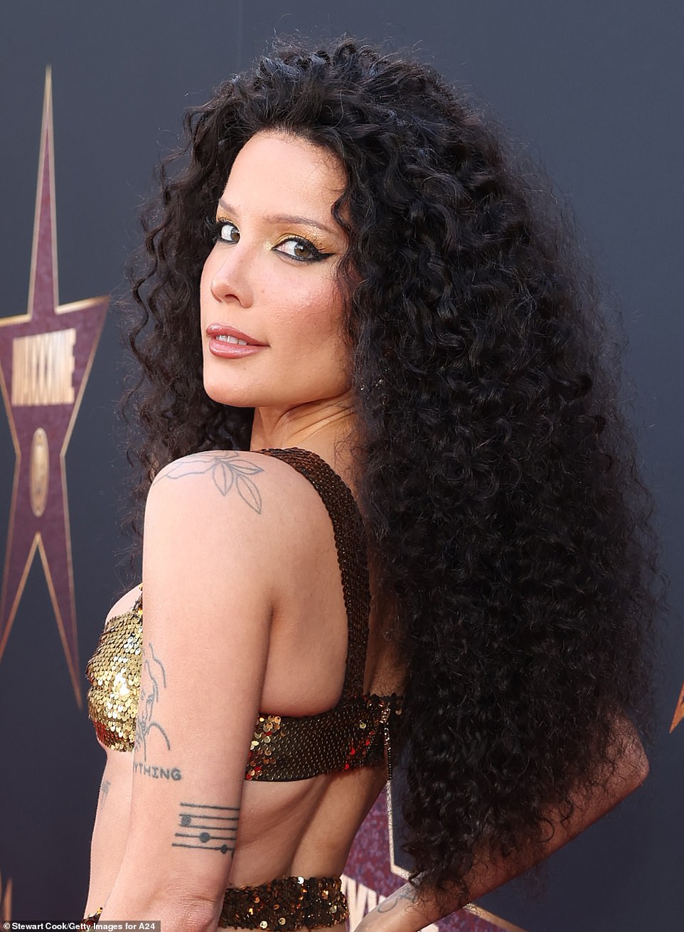 The three-time Grammy nominee wore yellow eyeshadow, likely from her brand About-Face Beauty, and she brought the disco realness with a voluminous, curly black wig over her pixie cut.