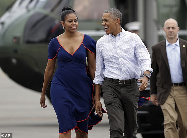 The Obamas walk on the tarmac of Martha's Vineyard Airport in West Tisbury, Massachusetts, August 2016 for their summer vacation