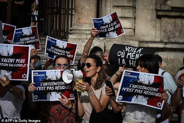 Protesters hold signs that read: "Anti-Semitism is not a residue", "+1000% in anti-Semitic acts, these are not just numbers", "Our lives are worth more than the imported conflict" And "Raped Jewish girl, Republic in danger" as they gathered to condemn the alleged anti-Semitic gang rape of a 12-year-old girl, during a rally in Lyon Terreaux Square in Lyon on June 18