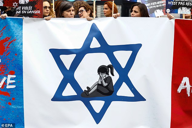 Protesters hold a banner during a rally against anti-Semitism in Paris, France, on June 20, as hundreds of people gathered after the rape of a girl near Paris on June 15