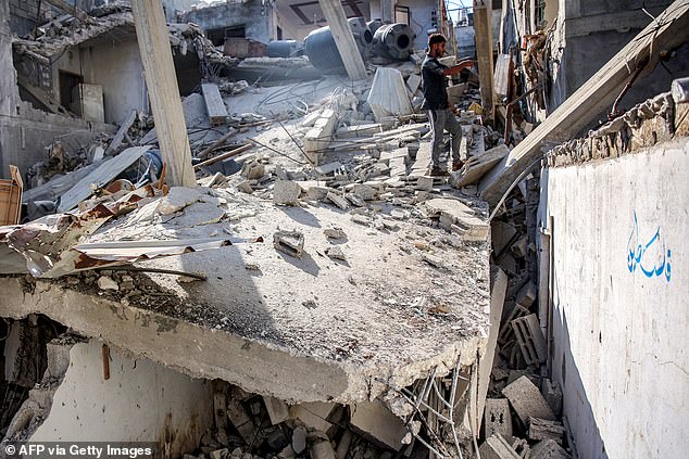 A man stands in the rubble of Ismail Haniyeh's sister's house after it was razed by Israeli bombardment