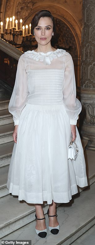 Adorned with a satin ruffled collar and a white bow, the actress paired the dress with some black and white heels and a white Chanel handbag