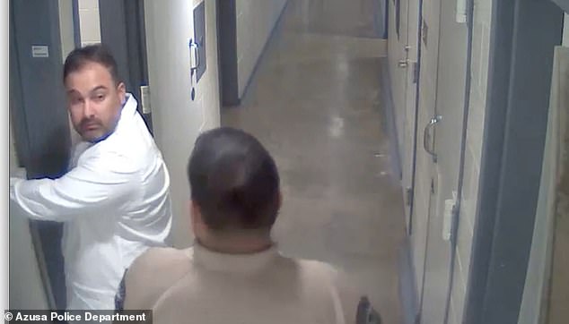 Still from a jail surveillance video shows an Azusa, California police officer escorting George Gascon's right-hand man, Iniguez, to a cell after a 2021 stop for public intoxication