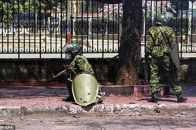 Kenyan riot police operate near the country's parliament during a protest against proposed tax increases