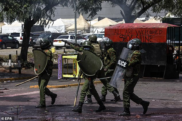 Police prepare to fire tear gas at demonstrators during a protest against proposed tax increases