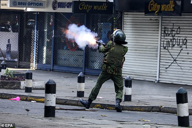 A police officer fires tear gas at demonstrators during a protest against proposed tax increases