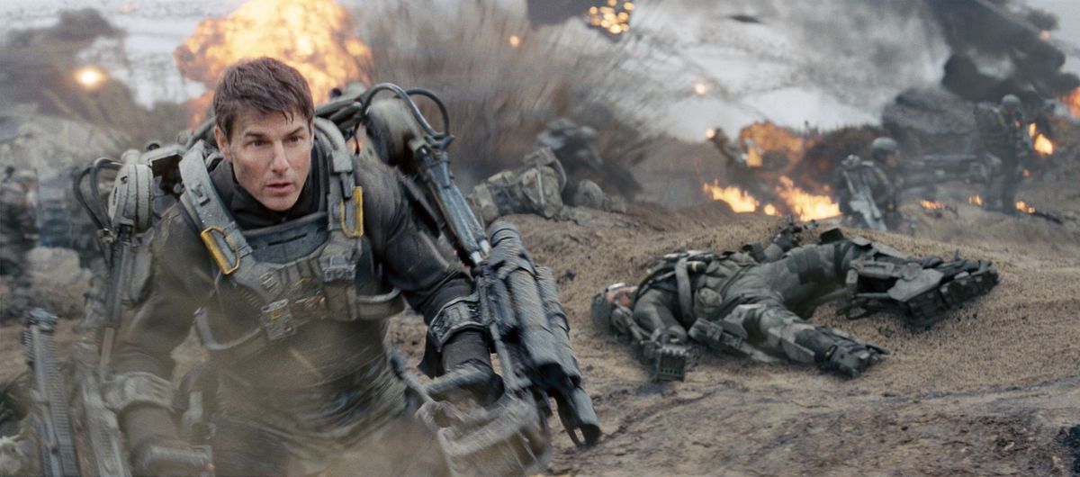 Tom Cruise as Cage in power armor storming an explosion-filled beach in Edge of Tomorrow.