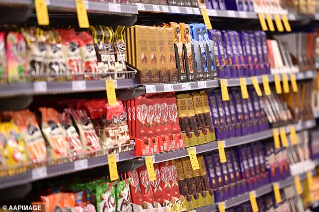 From July, the Natural Confectionery Co.  Australian retailers to stock bags of slimy snakes that contain 50 percent less sugar (stock image of the candy aisle at Woolworths)