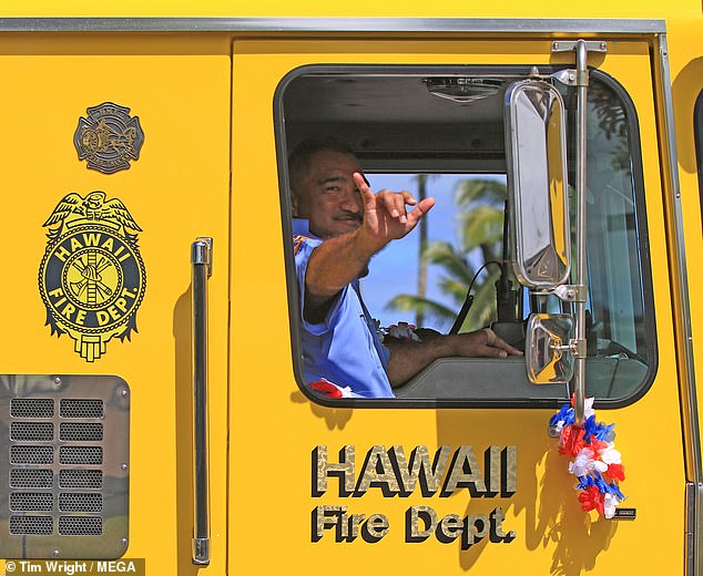 The striking gesture with the little finger and thumb is also known as the 'hang loose' symbol.  (Pictured: A Hawaii Fire Department firefighter holding up a shaka)