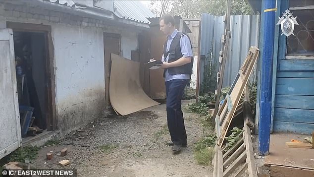 Laptops and disks with pornographic content were seized from the home.  The photo shows an investigator searching the property