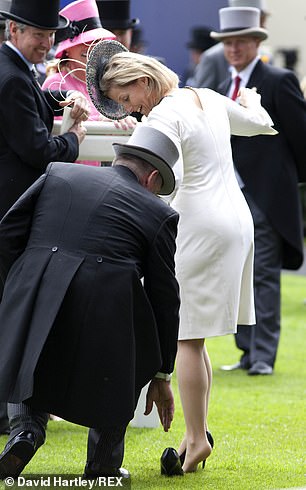The royal tried to keep her balance as a man rushed to her aid and ensured the shoe was safely back on her foot