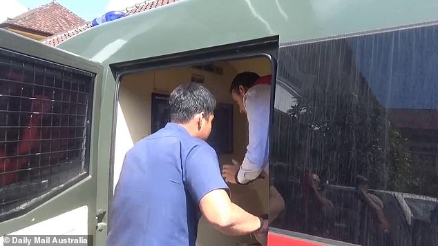 Pictured is Troy Smith (wearing a white shirt) about to step out of a prison van in Bali on Thursday
