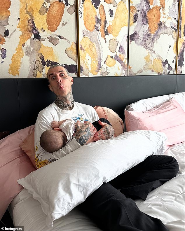 “I really like attachment parenting.  There's no way I'm divorcing him.  I love being home now, like I'm spending my time taking care of my baby and bonding with him,” she continued;  Kourtney's husband, Travis, pictured holding Rocky