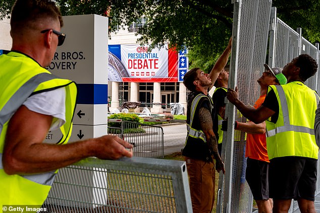 Workers set up a large security fence around CNN's headquarters in Atlanta, Georgia, on Thursday morning ahead of the showdown