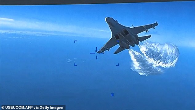 This handout image, taken from a video released by U.S. European Command (USEUCOM) on March 16, 2023, shows footage from a U.S. Air Force MQ-9 drone as it is approached for the first time by a Russian SU-27 aircraft, jettisoning fuel, over the Black Sea on March 14, 2023.