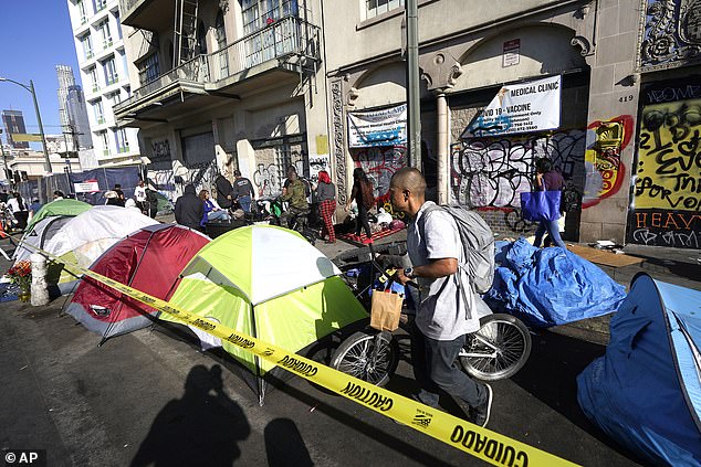 People line up past temporary tents to partake in a free Thanksgiving meal offered by the Union Rescue Mission as the Los Angeles Skid Row