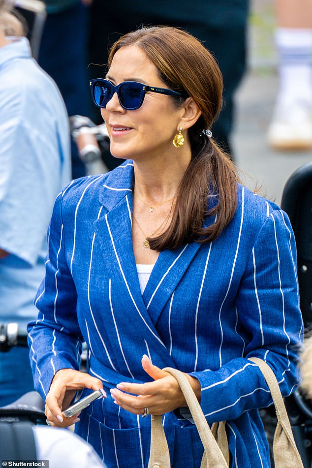 Mary looked stylish in a blue wrap blazer with white pinstripes and wayfarer shades as she watched the parade
