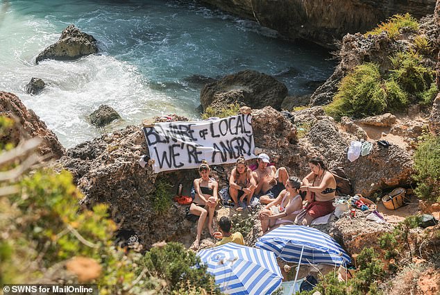 Members of the public protest at Calo des Moro beach outside Santanyi, Mallorca, on June 16 - where tourists were told to 'go, go, go'