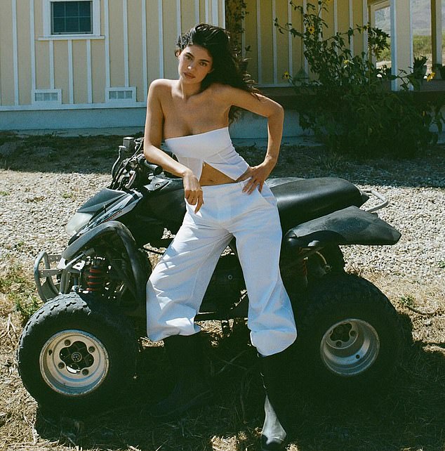 Jenner posed near an ATV with a yellow house in the background
