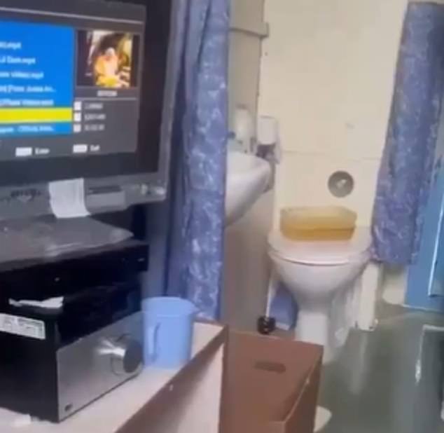 Footage from the cell shows a TV and piles of clothing on a bunk bed