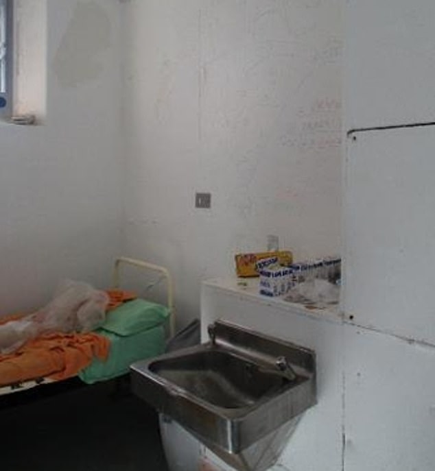 A cell in Wandsworth with graffiti on the stained walls