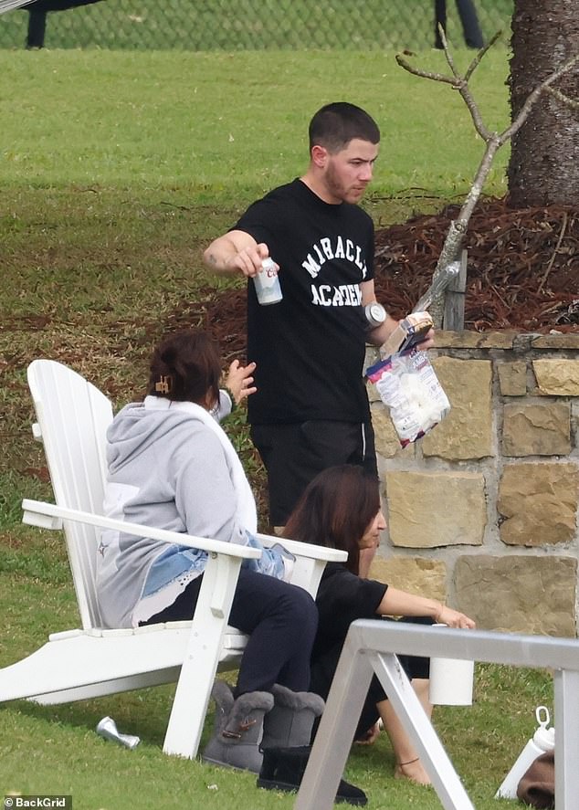 Nick Jonas, 31, showed off laid-back style in a black Miracle Academy T-shirt and black shorts