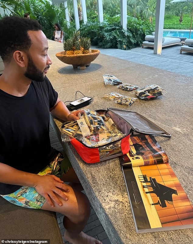 In another photo, Legend, 45, sits as he builds a Lego creation during his free time