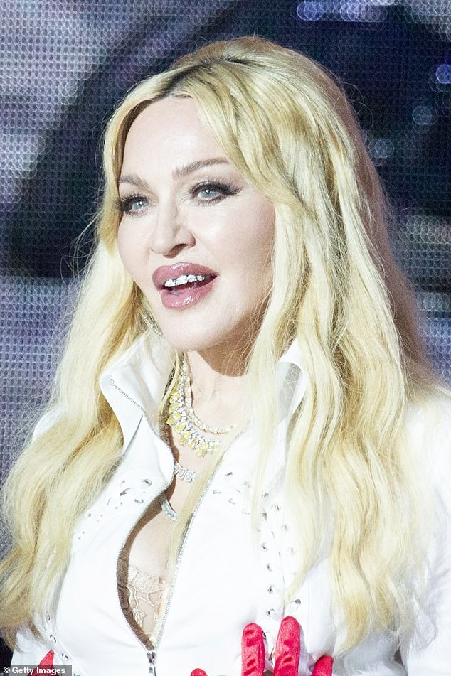 Madonna completed the look with sparkling jewel chains that hung down her neckline, as well as a diamond grille in her mouth
