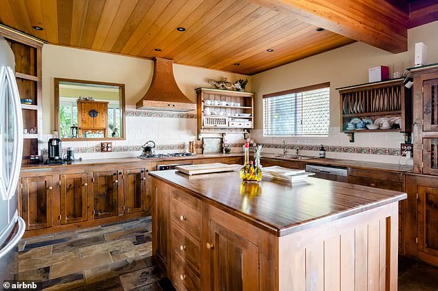 A huge, nostalgic country kitchen finished with warm wooden panelling