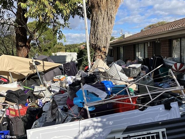 Outraged neighbors in an Adelaide suburb have demanded their council clear out a house piled so high with belongings (pictured) that the owner can't even live in it