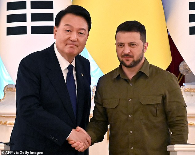 Ukrainian President Volodymyr Zelensky and his South Korean counterpart Yoon Suk Yeol shake hands after their statements following the talks in Kiev on July 15, 2023