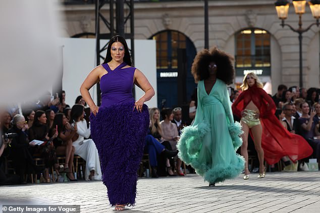 Ashley Graham wore a quirky purple dress and bold '70s makeup as she walked the Vogue World Paris catwalk on Sunday evening