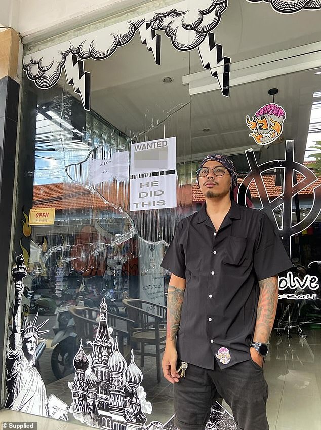 Nizar Simahardy (pictured) outside his tattoo parlor, Evolve Ink Studio in Denpasar, the capital of Bali, where he has put up a poster with the driver's license of the man he claims smashed his window