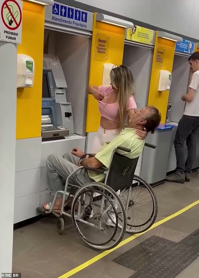 The woman placed her left hand to prevent the man's neck from tilting back as she put the money in her top