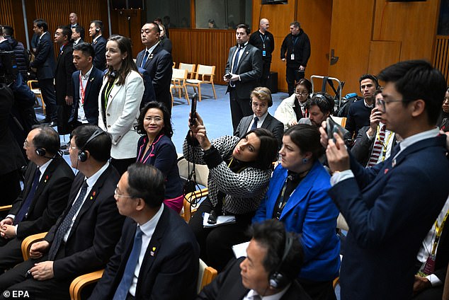 Ms Lei (pictured sitting and looking to the right) was hidden from view of television cameras by Chinese media officials (pictured, far right)