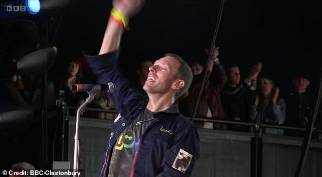 Dakota Johnson *pictured far left) proved her relationship with Chris Martin is still going strong when she proudly watched her boyfriend perform at Glastonbury on Saturday night
