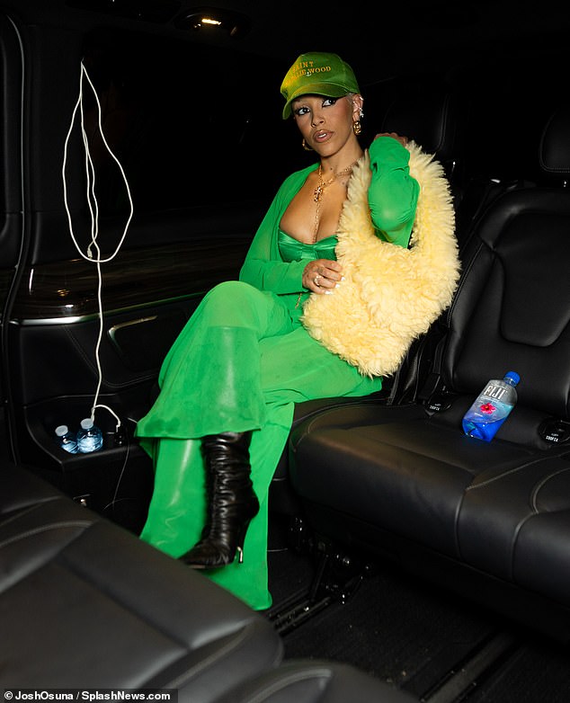 The Kiss Me More singer, 28, stopped into trendy Parisian discotheque L'arc wearing a Kelly green ensemble consisting of a long-sleeved wrap top with the entire front open to reveal a matching bandeau bra