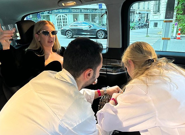 A little tweak: Ellie Goulding shared a photo of two stylists adjusting her outfit for the Tamara Ralph Haute Couture show as she sat in the back of a limousine on the way to the Paris venue