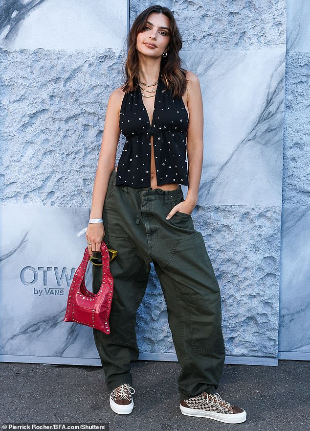 It's been a busy week for Emily, who showed off her abs in a black crop top with silver studs as she attended a Vans event in Paris on Friday (pictured)