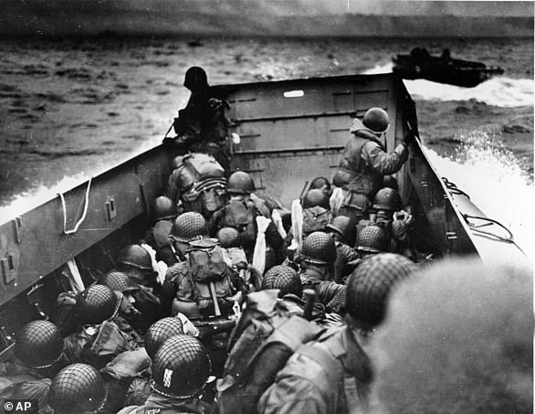 An American landing ship full of helmeted soldiers sails to the coast in Normandy on June 6, 1944