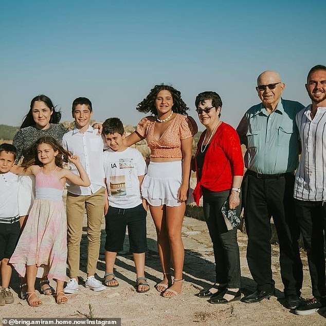 Amiram Cooper (second from right) and Nurit Cooper (red shirt) are pictured with their family