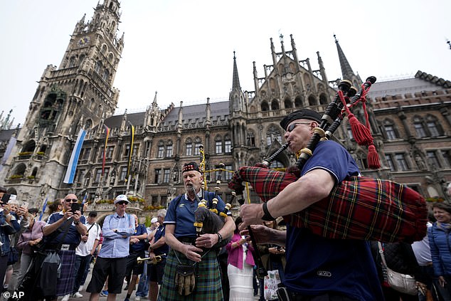 Five Scotland fans have been injured in a head-on collision on the wrong side of the road as they arrived in Germany for their team's opening match of the 2024 European Championship.  Pictured (not related to the crash): Two men play bagpipes on Marienplatz Square before a Group A match between Germany and Scotland during the Euro 2024 football tournament in Munich, June 14