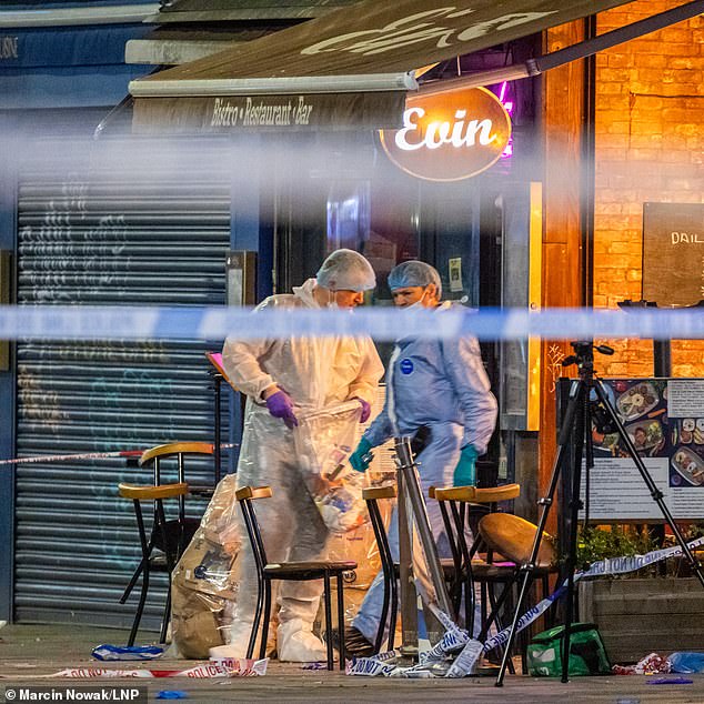 Pictured: Forensic officers collect evidence at the scene in Dalston, east London