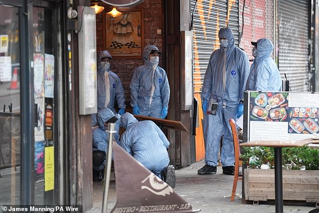 Forensic police officers at the scene of the shooting in Kingsland High Street, Hackney, East London,