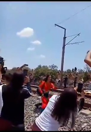 The woman prepared for the selfie by kneeling close to the train